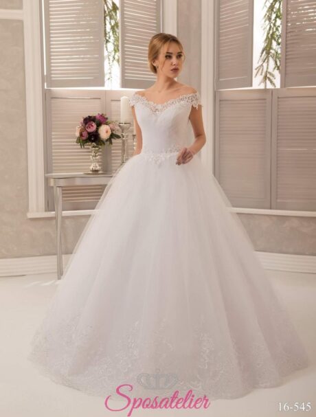 Abito da sposa con scollatura omerale, silhouette dal taglio a trapezio e in stile principessa. Una splendida creazione confezionata in pizzo, tulle