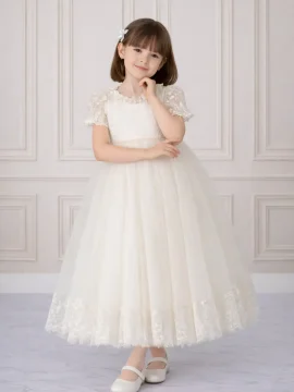 Bambina con abito lungo da cerimonia color avorio, corpetto in pizzo, cintura di perle e gonna in tulle con bordo ricamato