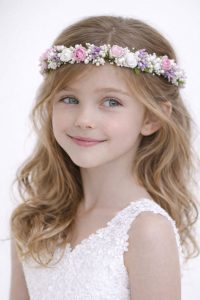 Coroncina per capelli bambina con mix di fiori rosa, bianchi e lilla, arricchita da perline e foglie verdi per cerimonia.