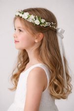 Coroncina per capelli bambina comunione vista di profilo, con roselline bianche, boccioli rosa, perline e fiocco posteriore in raso su capelli mossi biondi