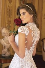 Abito da sposa color cipria con ricami in pizzo barocco avorio, scollo a V e maniche corte.