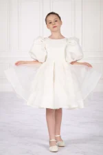 Bambina con abito da damigella bianco/avorio con maniche a sbuffo e gonna ampia in tulle