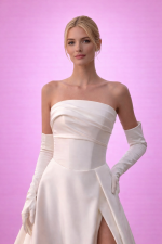 Abito da sposa a fascia con spacco alto figura intera su sfondo rosa