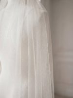 Dettaglio del tulle avorio con delicata finitura glitterata