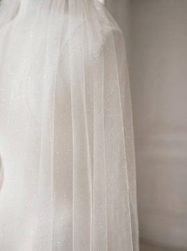 Dettaglio del tulle avorio con delicata finitura glitterata