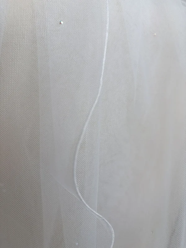 Dettaglio dei cristalli e del bordo sottile del velo da sposa