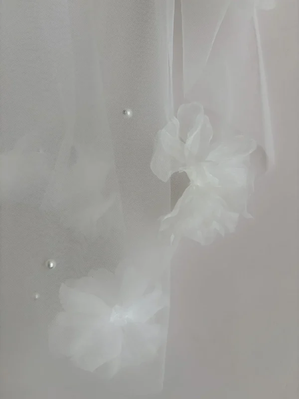 Dettaglio dei fiori 3D e delle perle sul tulle del velo da sposa