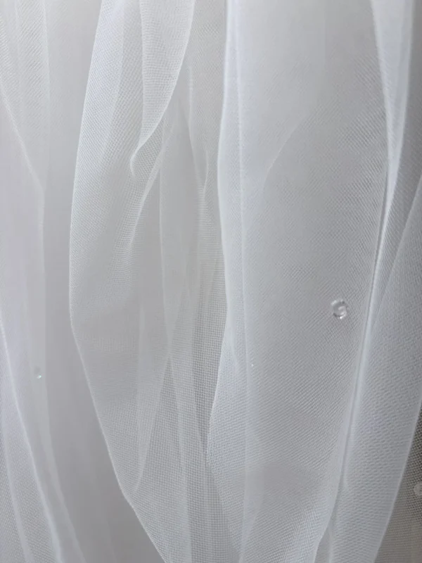 Dettaglio dei cristalli trasparenti applicati sul tulle del velo da sposa