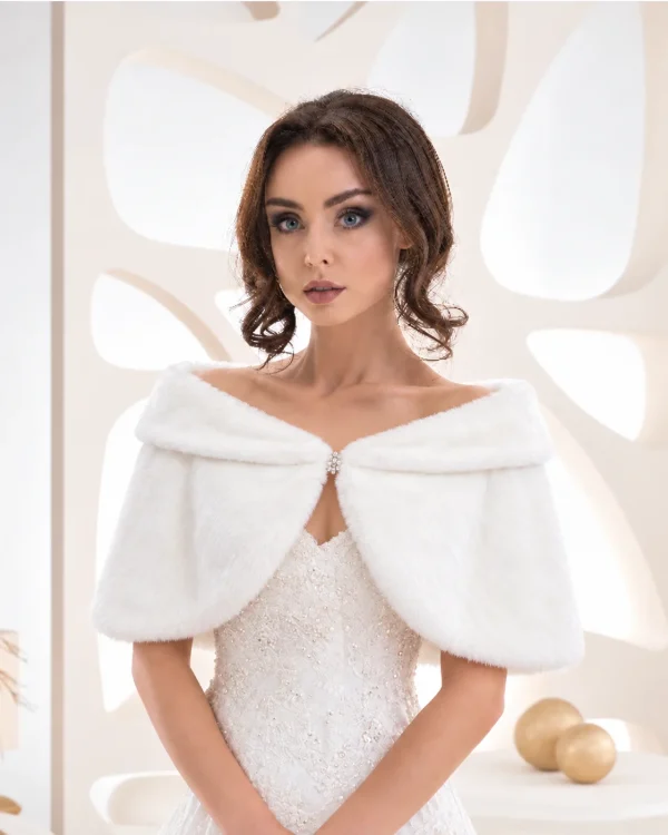 Sposa con mantella bianca effetto pelliccia e chiusura gioiello frontale