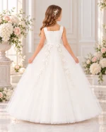 Vista posteriore abito Prima Comunione bambina avorio con cerniera centrale, applicazioni floreali e gonna lunga vaporosa in tulle.
