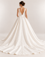 Vista posteriore abito da sposa principesco avorio con schiena scoperta a V, gonna ampia con pieghe e lunga fila di bottoncini fino allo strascico.