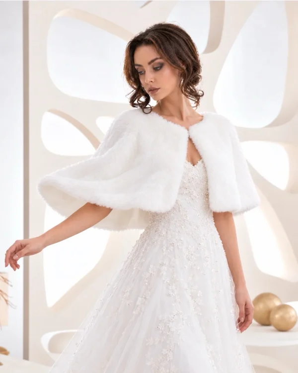 Sposa con mantella bianca corta effetto pelliccia sopra abito ricamato