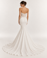 Vista posteriore abito da sposa a sirena avorio con schiena scoperta, corsetto trasparente ricamato, bottoncini rivestiti e ampio strascico.