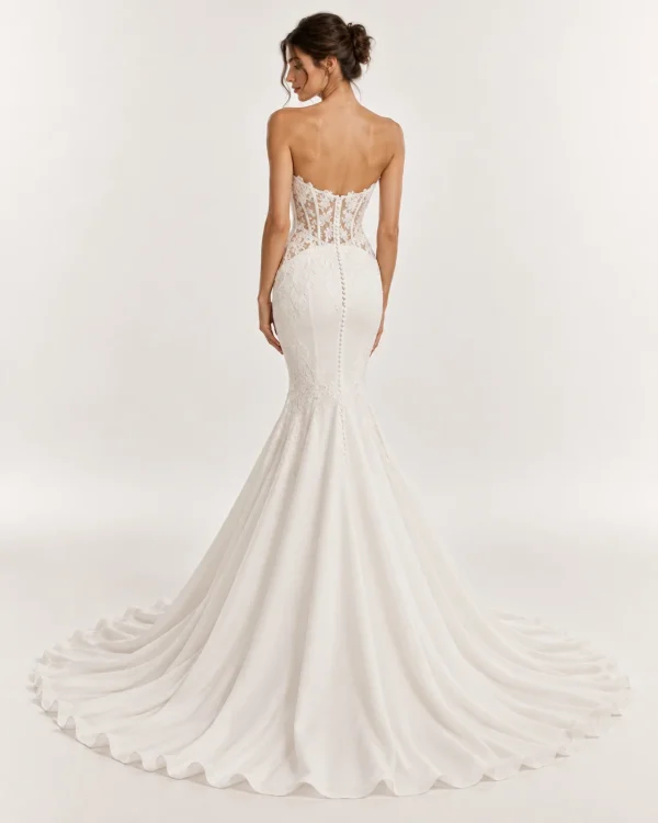 Vista posteriore abito da sposa a sirena avorio con schiena scoperta, corsetto trasparente ricamato, bottoncini rivestiti e ampio strascico.