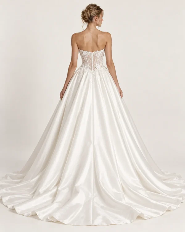 Vista posteriore abito da sposa principesco avorio con corsetto in pizzo floreale trasparente, stecche verticali, bottoncini e ampia gonna con strascico.