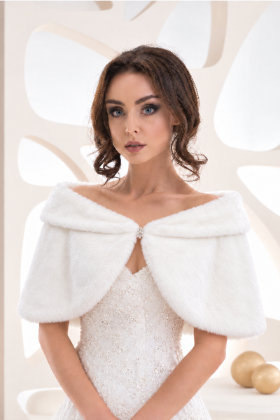 Sposa con mantella bianca effetto pelliccia e chiusura gioiello frontale