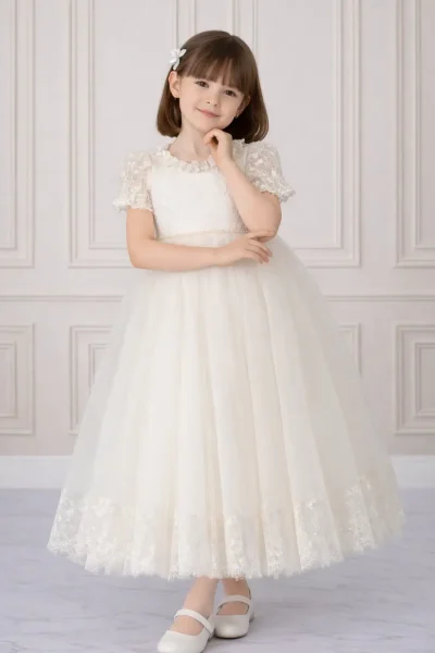 Bambina con abito lungo da cerimonia color avorio, corpetto in pizzo, cintura di perle e gonna in tulle con bordo ricamato