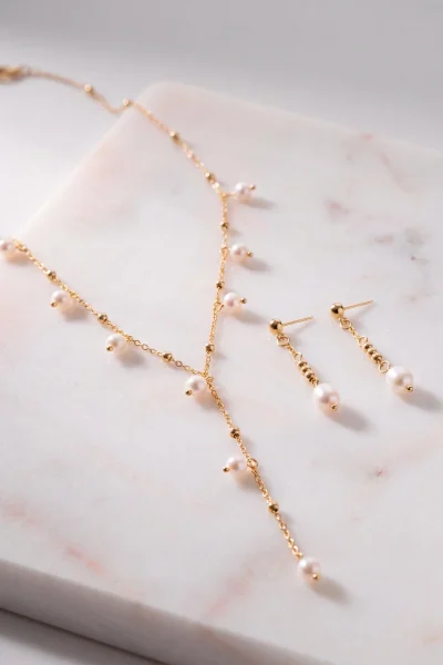 Dettaglio delle perle sospese sulla collana dorata NS1035