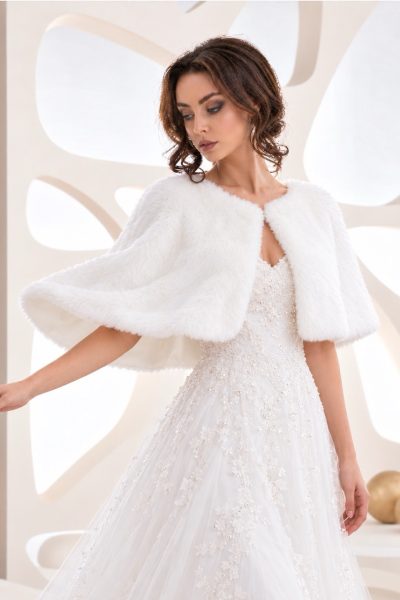 Sposa con mantella bianca corta effetto pelliccia sopra abito ricamato