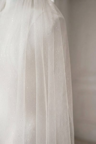 Dettaglio del tulle avorio con delicata finitura glitterata