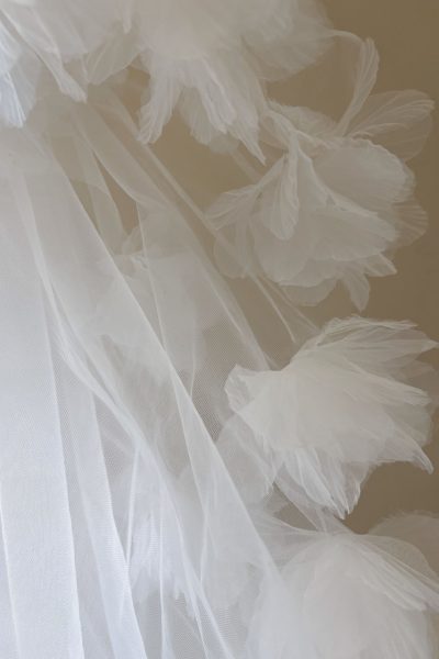 Dettaglio dei fiori 3D in tulle sul bordo del velo da sposa corto