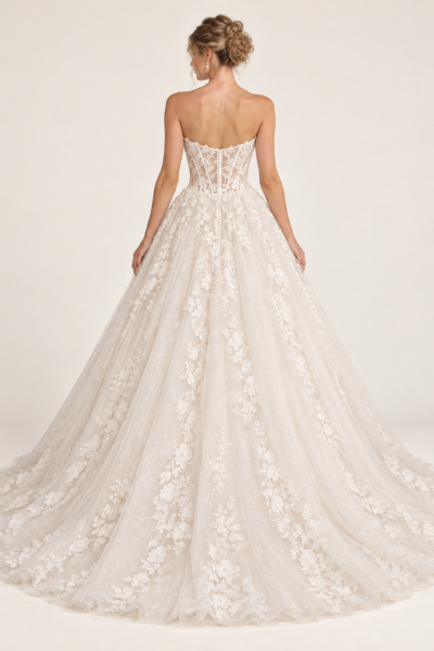 Vista posteriore abito da sposa principesco avorio con corsetto in pizzo floreale trasparente, bottoncini rivestiti e ampio strascico in tulle decorato.